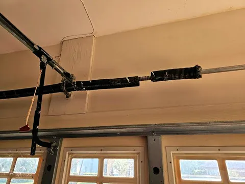 Torsion springs on the shaft above a garage door with windows